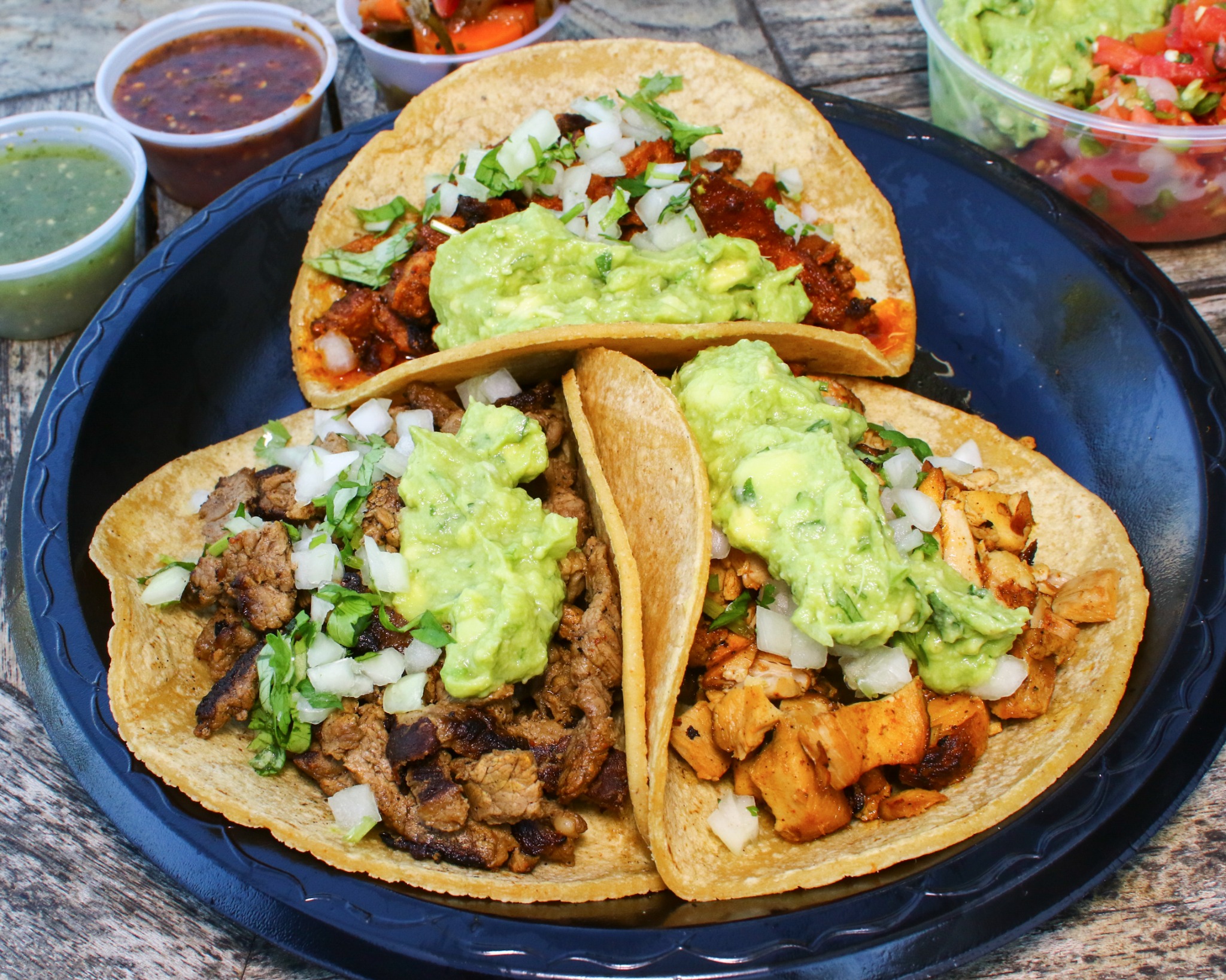 Trio of carne asada, pollo, and al pastor tacos